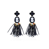 A pair of black and white cameo and pearls-style drop earrings with floral details and long dangling black strands, shown on a plain white background. Avan-garde-style handmade earrings