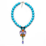 Luxury turquoise gemstone necklace with a multicolor sculptural pendant featuring blue, purple, orange, green, and teal stones — quiet radiance, modern artistic elegance, intimate poetic presence; perfect for refined occasions, evening looks, gallery events, and elevated daytime style; handcrafted one‑of‑a‑kind jewelry by SILDARE Jewelry