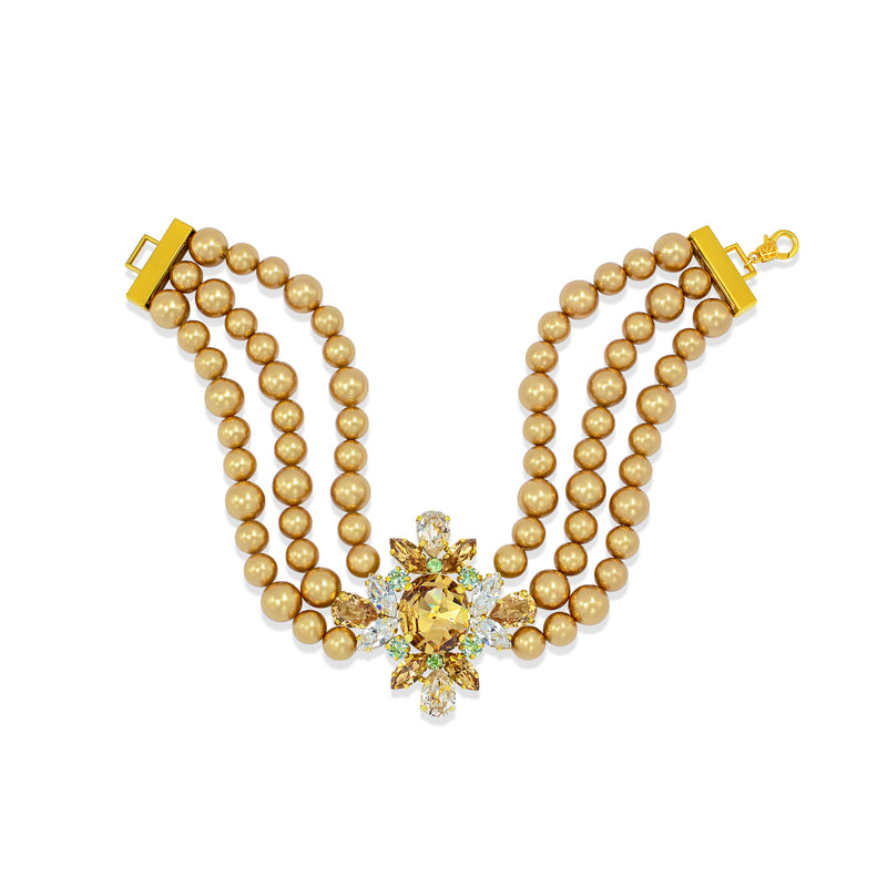 A double-strand pearl necklace with a gold plated central floral starburst charm featuring a large yellow gemstone and small clear crystals, shown on a plain white background.