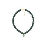 A beaded necklace made of dark green round beads with a small green rectangular pendant and gold-tone clasp, shown on a plain white background.