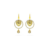 A pair of gold drop earrings featuring a textured heart-shaped charm inside a circular frame, with a small teardrop crystal pendant hanging below, set against a plain white background.
