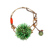 A vintage-style statement necklace featuring a large green spiky bead centerpiece, a dangling green marble bead, and a bright orange-red oval accent bead, all set in a bronze-toned metal chain on a white background.